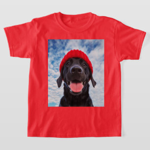 Camiseta Labrador feliz en una Beanie Roja bajo un cielo az
