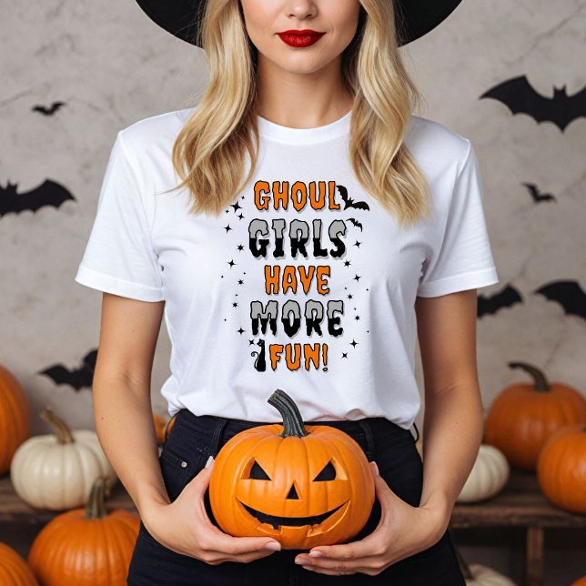 Camiseta Los Chicas de Ghoul se divierten más en Halloween  (Women in a white Ghoul Girls have more fun shirt with Halloween decor.)