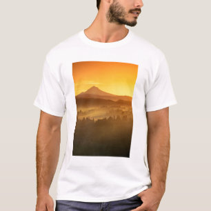 Camiseta Los colores naranjas del amanecer colorean la nieb