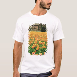 Camiseta Los tulipanes de primavera florecen frente a un vi