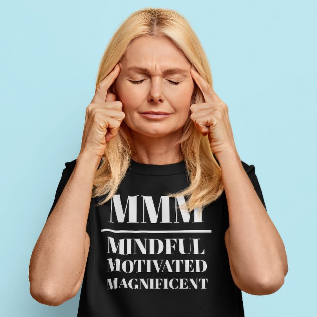 Camiseta MMM- Mentísima, Motivada, Magnífica (Middle aged Caucasian woman wears a t-shirt that reads "MMM: Mindful, Motivated, Magnificent")