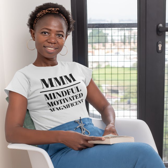 Camiseta MMM- Mentísima, Motivada, Magnífica (Young black woman wearing a "MMM:Mindful, Motivated, Magnificient" white t-shirt.)