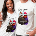 Camiseta Navidades de parejas personalizadas de guiones com<br><div class="desc">Camisetas navidades comprometidos y personalizados. Esta acuarela presenta un ilustracion de moda de una pareja que lleva sombreros de santa. "Engaged" (Involucrado) está escrito a mano en escritura moderna y la plantilla está lista para que añada sus nombres y el año u otro texto personalizado.</div>