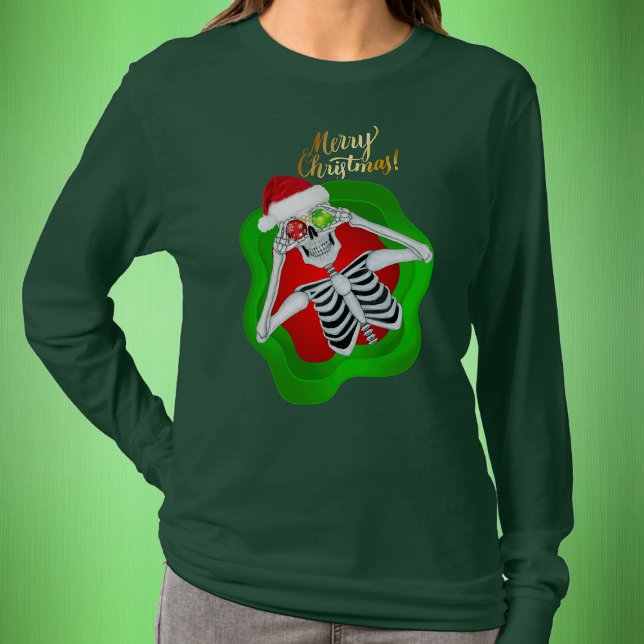 Camiseta Navidades Silly Skeleton Santa Hat Spatter forma (Fun Skeleton in Santa Hat in splatter shape with Gold Merry Christmas text on green womans shirt.)