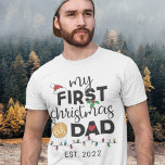 Camiseta Primera Navidad como padre - familia que combina l<br><div class="desc">Muéstrate tu alegría por tu primera Navidad como padre con esta encantadora camiseta decorada con un sombrero de Santa Claus rojo,  hojas verdes y huecas,  una bola de oro,  un corazón rojo y coloridas luces Navidades.</div>