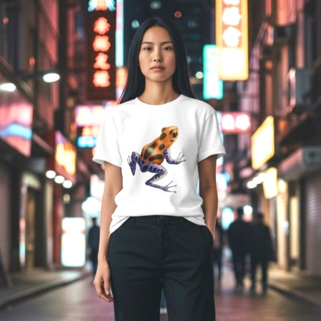 Camiseta Rana Veneno (A vibrant orange and blue poison dart frog on a classic white tee, on a woman in the city at night.)