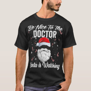 Camiseta Sé Agradable Con El Médica Santa Está Viendo Xmas 