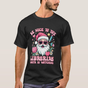 Camiseta Ser amable con la bibliotecaria Santa está viendo 