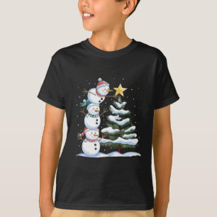 Camiseta Tres muñecos de nieve están arreglando un árbol de