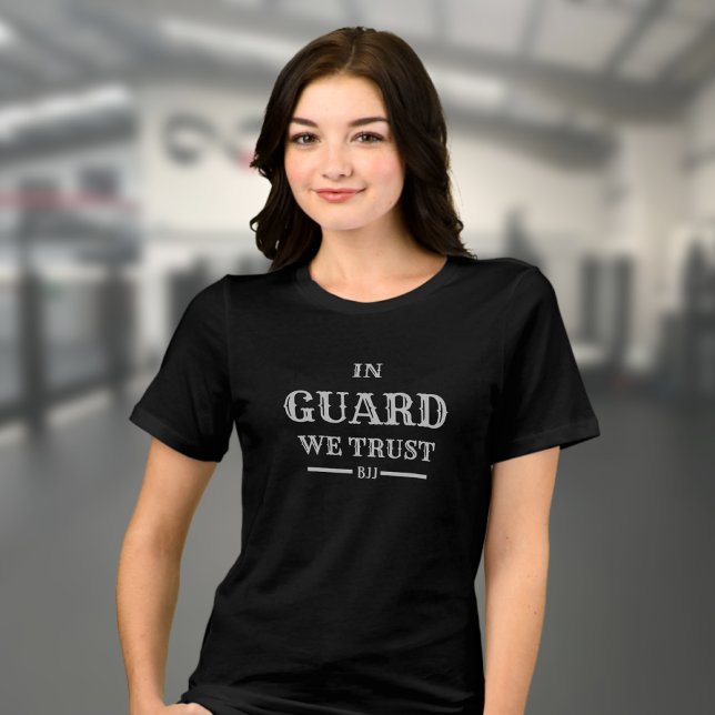 Camiseta Triblenda BJJ en guardia confiamos en la mujer brasileña Jiu (Woman's Brazilian Jiu Jitsu T-shirt in black on a female model in a gym. )