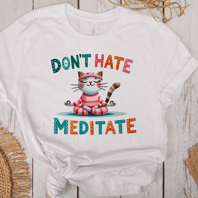 Camiseta Triblenda "No odies a meditar" graciosos amantes de un gato ("Don't Hate Meditate" Funny Cat Lovers Tri-Blend Shirt on a desk with boho decoration)