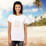 Camiseta Tribu de novias bachillerato guión del partido de<br><div class="desc">Para una ducha nupcial o un fin de semana de bienestar y spa de soltera. Un fondo blanco moda. Personaliza y agrega el nombre de la novia. Letras negras y doradas. Con el texto: tribu de novias. La palabra tribu está escrita con un guión moderno de estilo con letras a...</div>