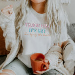 Camiseta Tropic tema de TYRA 90 como si fuera bachillerato<br><div class="desc">Esta camisa de soltera con novia muestra una tipografía de neón con temas de los años 90 con las palabras "trópico como caliente,  estoy atando el nudo". Esta camisa se combina perfectamente con la opción de la soltera "ella está atando el nudo".</div>