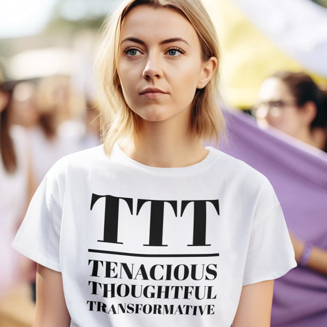 Camiseta TTT - Tenaces, reflexivos, transformadores (Woman wears a "TTT: Tenacious, Thoughtful, Transformative" white t-shirt.)