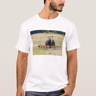 Camiseta Un joven muchacho conduciendo un tractor cosechand