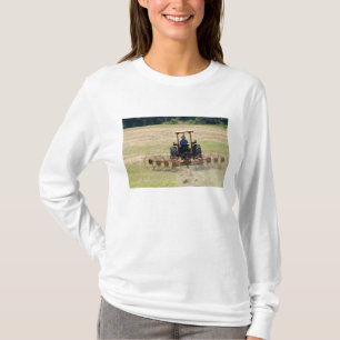 Camiseta Un joven muchacho conduciendo un tractor cosechand