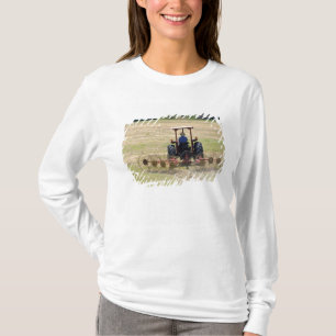 Camiseta Un joven muchacho conduciendo un tractor cosechand
