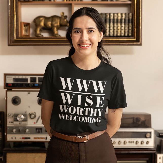 Camiseta WWW- Sabio, digno, bienvenido (Young woman wears a black t-shirt that read "WWW: Wise, Worthy, Welcoming")