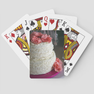Cartas de juego con pastel rosa y blanco en la par