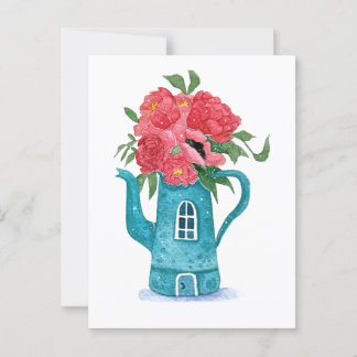 Casa azul de tetera con tarjeta de flores rojas