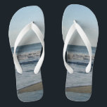 Chanclas Arena de la playa de Ocean Waves Blue Sky<br><div class="desc">Cielo azul bonito con nubes blancas iluminadas, mar azul, olas del océano estrepitosas y rocas volteadas de arena de arena fina. Mostrado con cintas blancas anchas y pie de página blanco. Vea las opciones para roscas en correas delgadas para obtener más colores de correa. Perfecto para su diversión de verano,...</div>