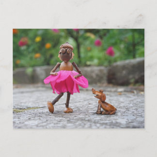 Chica elfo de maíz con vestido rosa con una postal