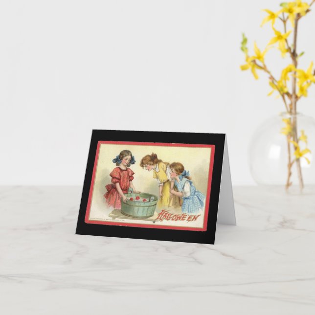 Chicas de Halloween buscando manzanas en tarjeta a (flor amarilla)