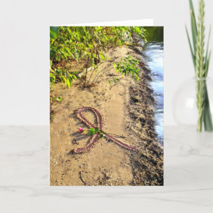 Cinta rosada con tarjeta de cáncer de mama en aren