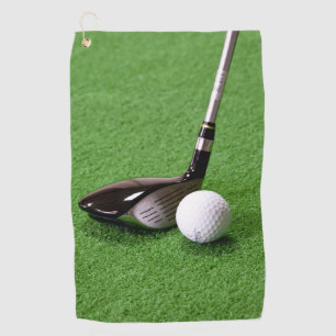 Club de golf y bola en una superficie verde Toalla