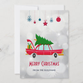 Coche rojo retro que lleva un árbol de Navidad