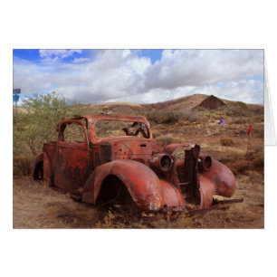 Coche viejo que aherrumbra en paisaje del desierto