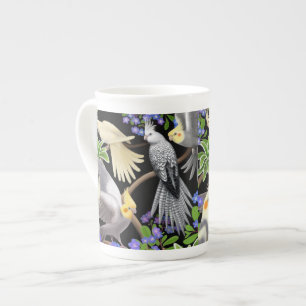 Cockatiels en taza de la porcelana de hueso de las