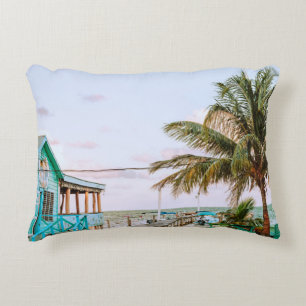 COJÍN DECORATIVO CASA DE MADERA AZUL CERCA DEL CUERPO DE AGUA