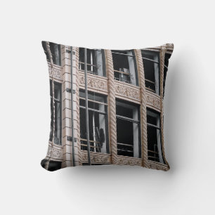 COJÍN DECORATIVO EDIFICIO DE CONCRETO MARRÓN CON VENTANAS DE VIDRIO