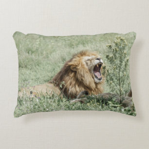 COJÍN DECORATIVO LEÓN SOBRE LA GRASA VERDE DURANTE EL DÍA