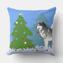 Malamute de Alaska decorando árbol de Navidad