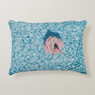Cojín Decorativo Mujer en boya rosa rodeada de un cuerpo de agua en