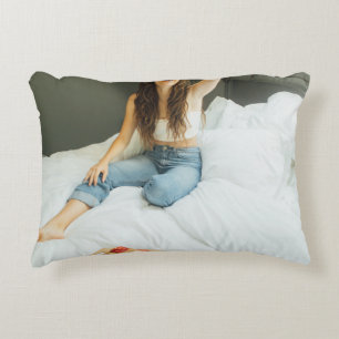 Cojín Decorativo Mujer sentada en la cama sosteniendo a su gorra