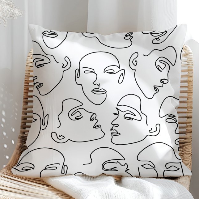 Cojín Decorativo Rostros de dibujo de líneas contemporáneas (Contemporary Line Art Drawing Faces Throw Pillow on a sunny rattan armchair.)