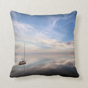 Cojín Decorativo Un velero solitario en las aguas tranquilas de