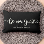 Cojín Lumbar Sea nuestro Personalizado invitado Textos Familia<br><div class="desc">Moderna y moderna caligrafía de escritura con un corazón florido que dice "Sé nuestro invitado" en esta elegante almohada de lumbar negro y marfil,  perfecta para recibir a los huéspedes en su casa,  alquiler de vacaciones o alojamiento y desayuno.</div>