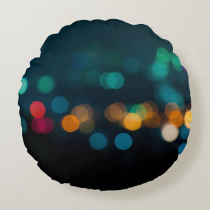 Cojín Redondo Broche de luz nocturna de la ciudad, fondo desenfo