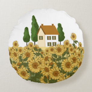Cojín Redondo Casa, árboles altos y un campo de girasoles en la