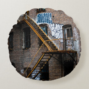 COJÍN REDONDO EDIFICIO DE LADRILLO MARRÓN CON LADDER METALIZADO 