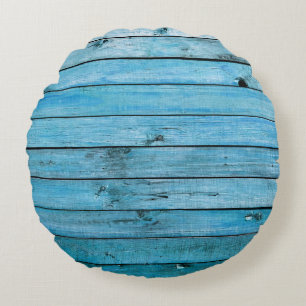 Cojín Redondo Madera natural azul, fondo texturado.