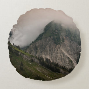 COJÍN REDONDO MONTAÑA VERDE Y GRIS BAJO NUBES BLANCOS