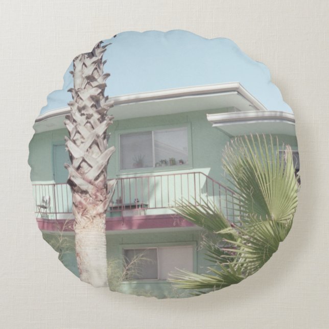 COJÍN REDONDO PALM TREE CERCA DE LA CASA DE CONCRETOS BLANCOS (Anverso)