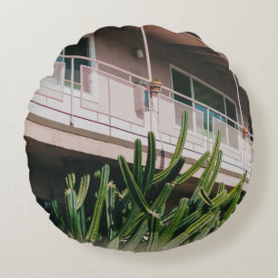 COJÍN REDONDO PLANTA VERDE DE COLOR ROSADO CERCA DEL EDIFICIO