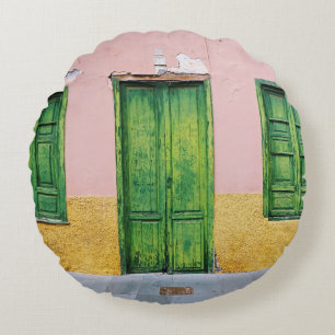 COJÍN REDONDO PUERTA DE MADERA VERDE EN LA PARED DE CONCRETO BLA