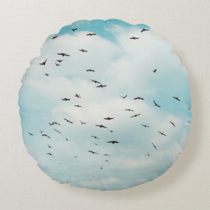 Cojín Redondo Un rebaño de paloma gris vuela sobre el cielo azul